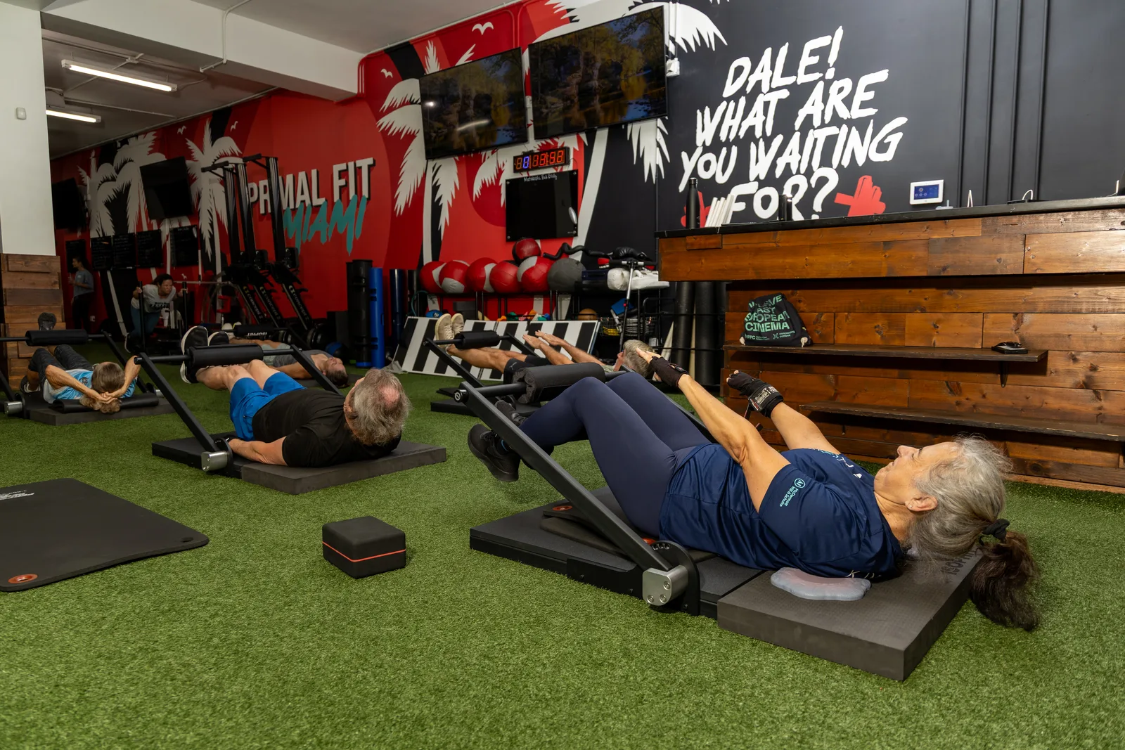 Coached ISOPHIT Strength Training for Adults 50+ at Primal Fit Miami Adults over 50 perform coached ISOPHIT isometric strength exercises on the floor at Primal Fit Miami.