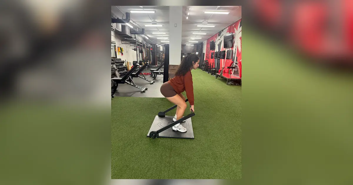 Woman performing an ISOPHIT isometric strength exercise at Primal Fit Miami