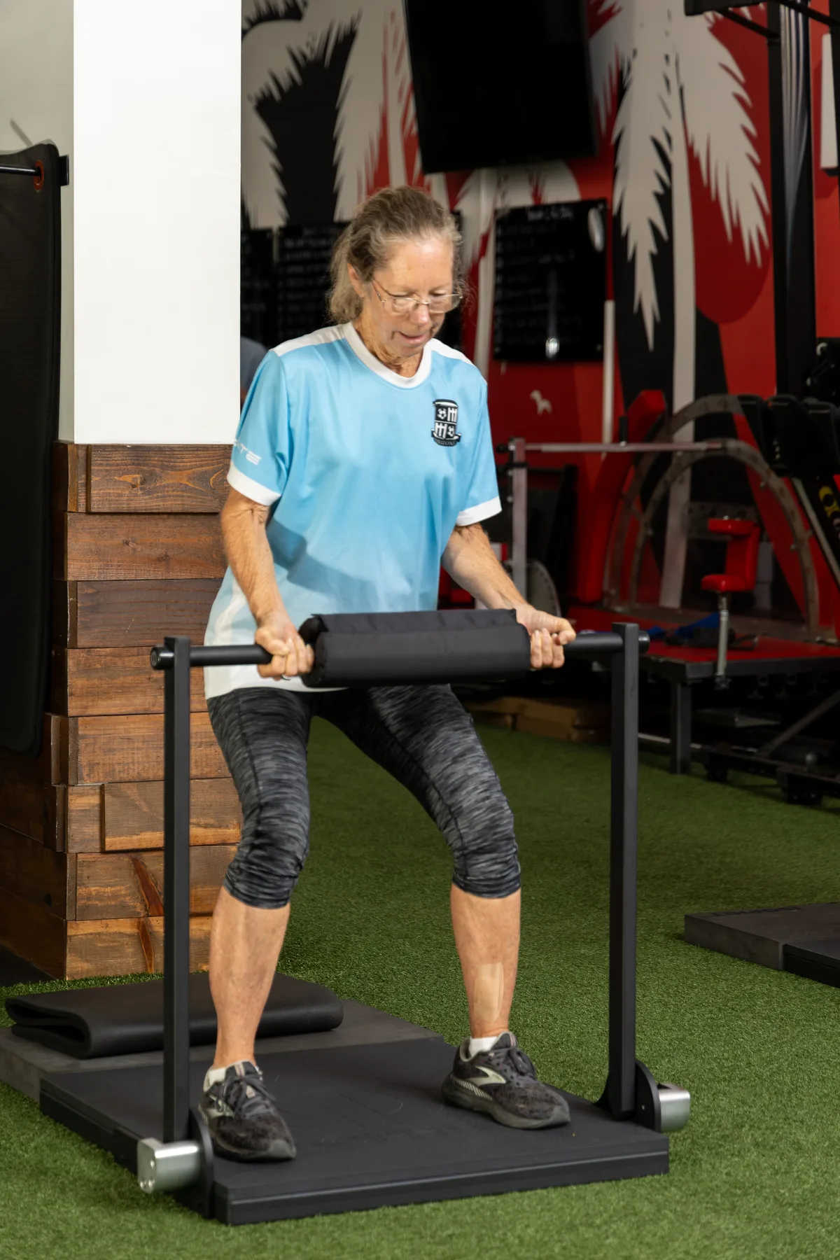 An adult over 50 performs a standing isometric pull on the ISOPHIT system at Primal Fit Miami.